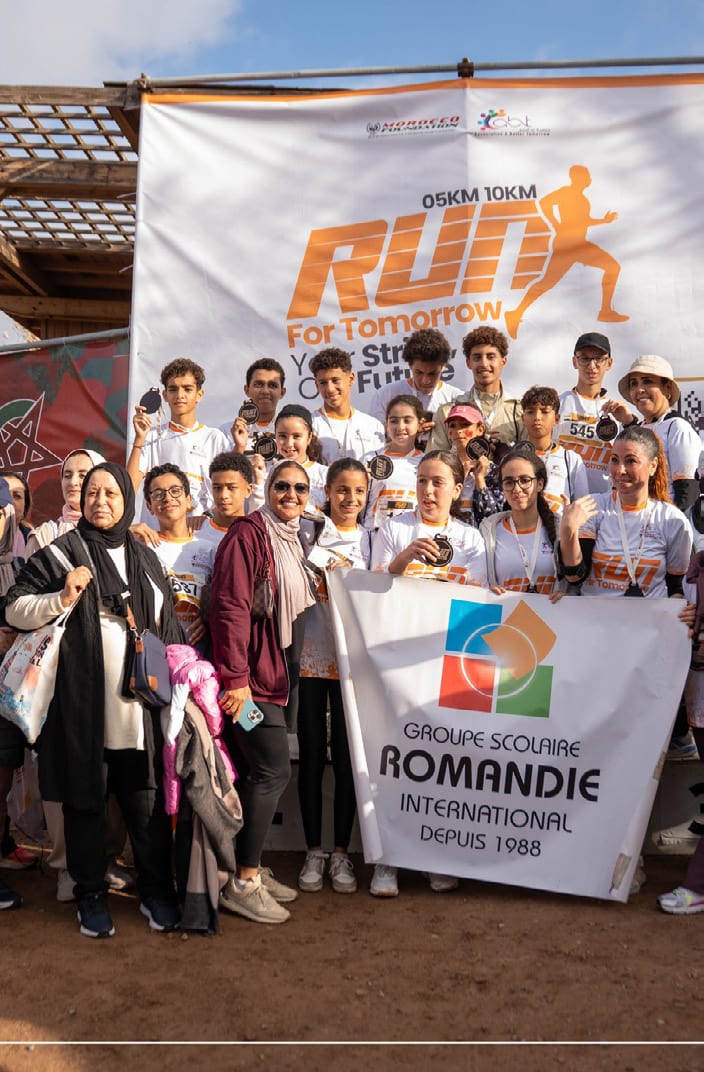 Les élèves du Groupe Scolaire Romandie réunis derrière leur banderole à l'arrivée de la course